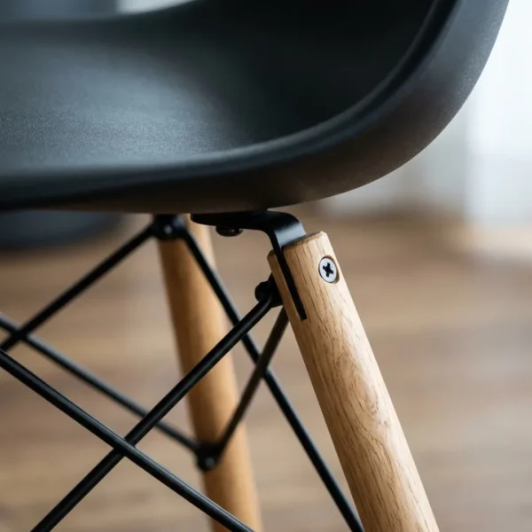 Black dining chair side profile showing wooden dowel legs and UV-coated ABS shell