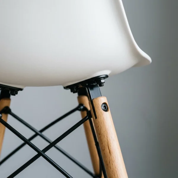 Stackable white dining chairs stored in a stack — space-saving DSW design